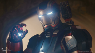 A person wearing red and silver metallic armor with glowing white eyes and a glowing light on the hand.