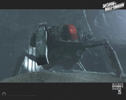 A dark, metallic multi-legged machine stands on rocky ground inside a dim cave.