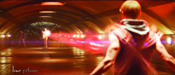 A person seen from behind in a tunnel facing a bright, glowing red light effect.