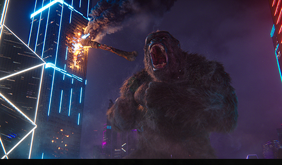A massive, furry gorilla roars amidst dark skyscrapers illuminated by blue neon lights.