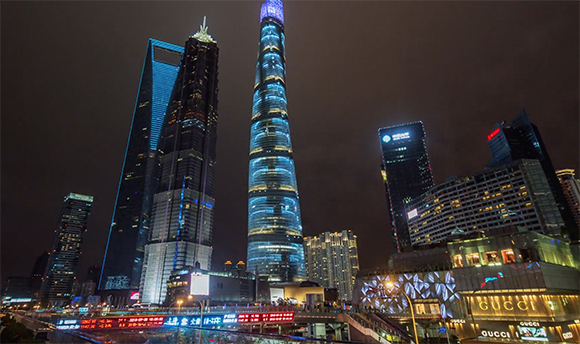 Illuminated skyscrapers including the Shanghai Tower and Jin Mao Tower against a dark night sky.