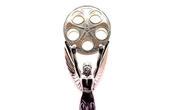 A silver trophy featuring a winged woman holding up a large film reel against a white background.