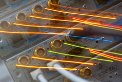 Close-up of electronic hardware with orange, red, and blue light trails streaking across the panel.