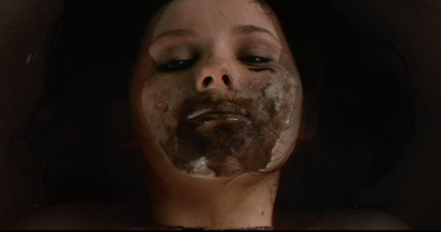 Close-up of a person's face with dark, textured substance smeared across their cheeks and mouth.