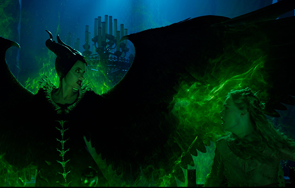 A dark, horned figure with large black wings looms over a woman in a green glowing mist.