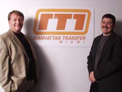 Two men in blazers standing on either side of a Manhattan Transfer Miami logo.