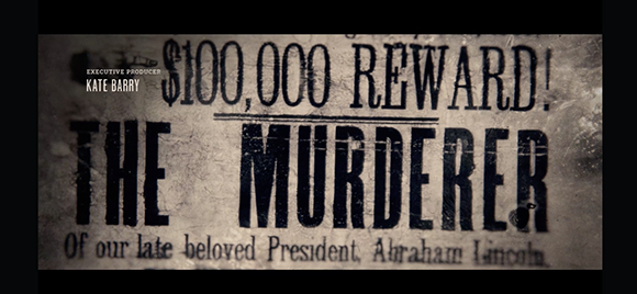 A distressed, vintage-style poster advertising a reward for the murderer of Abraham Lincoln.