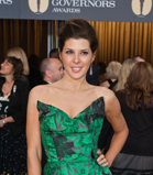 A woman smiling in a green strapless patterned dress at the Governors Awards.