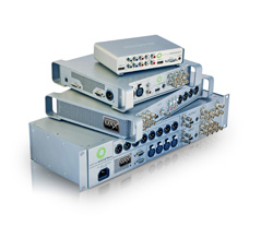 Four silver electronic audio interface devices of varying sizes stacked on a white surface.