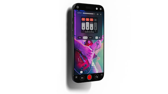 A black smartphone showing a digital audio workstation interface with faders and a video of a person playing guitar.