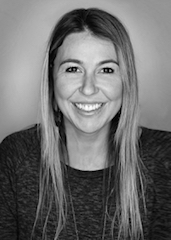 Black and white headshot of a smiling woman with long, straight hair looking directly at the camera.