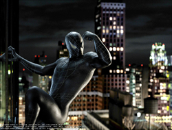 A person in a black patterned bodysuit clings to a glass building overlooking a city at night.