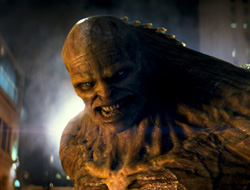 A close-up of a large, brown, textured creature with glowing eyes and sharp teeth.