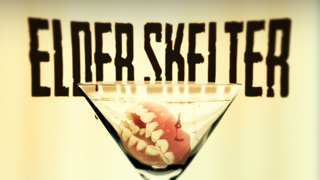 A martini glass filled with red liquid and human teeth, with large dark text reading 'ELDER SKELTER' behind it.