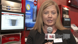 A woman holds a Post TV microphone in a room filled with computer monitors and server equipment.