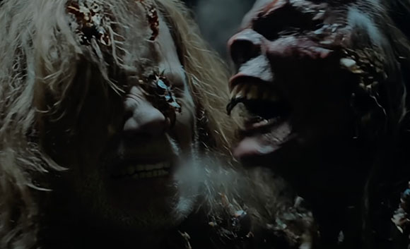 Two grotesque, decaying creatures with textured skin and bared teeth face each other in a dark setting.