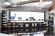A large, bright rectangular digital screen mounted on a dark wall in a modern room.