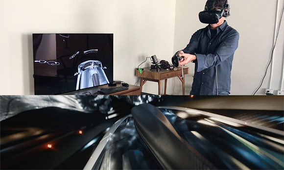 A person in a blue shirt uses a VR headset and controller to view a 3D car model on a monitor.