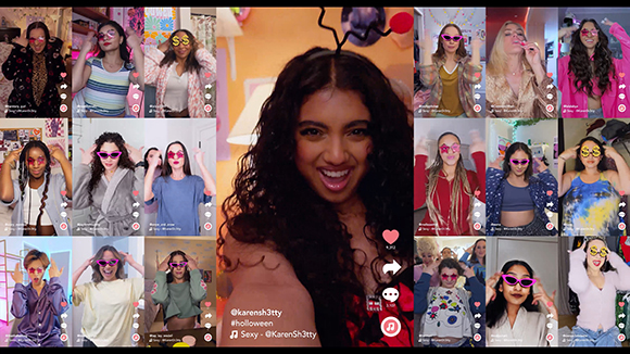 A grid of video thumbnails showing diverse people smiling, posing, and wearing colorful sunglasses.