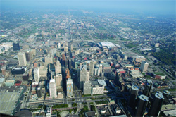 High-angle aerial view of a sprawling metropolitan city with skyscrapers and urban infrastructure.