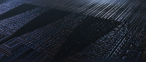 Close-up view of dark, parallel ridges and intricate geometric textures under dim lighting.