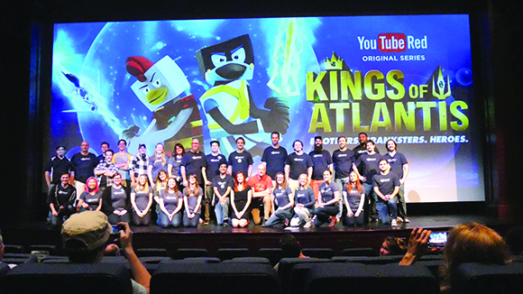 A large group of people standing on a stage in front of a YouTube Red promotional screen.