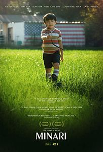 A young boy in a striped shirt walks through a lush green field toward the camera.