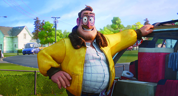 A large man with glasses and a beard wearing a yellow jacket stands beside a vehicle.
