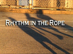 Shadows of people jumping rope on a paved surface with text overlay reading 'RHYTHM IN THE ROPE'.