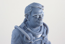 A blue 3D-printed bust of an older man wearing an astronaut suit and glasses.