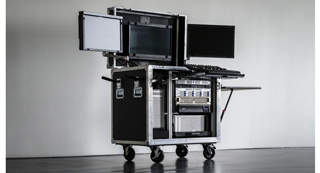 A black rolling equipment rack with several computer monitors and electronic hardware mounted on top.