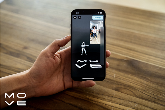 A hand holds a smartphone showing a fitness app with a white character and the word MOVE on a dark background.