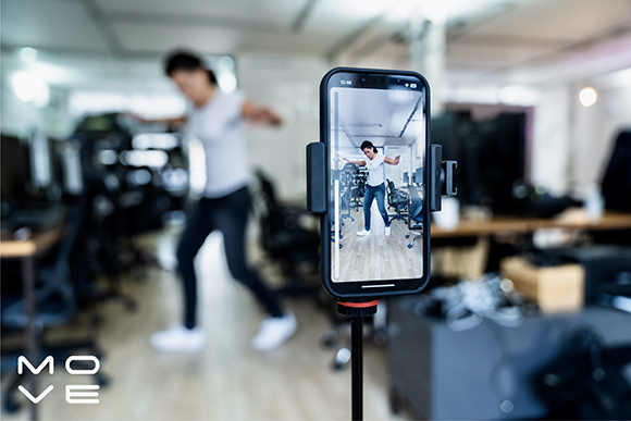 A smartphone on a tripod captures a person exercising in a blurred gym setting.