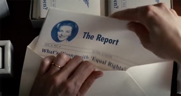 Hands pulling a document titled 'The Report' from a white envelope.
