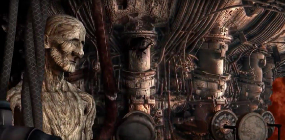 A carved wooden humanoid figure stands in front of intricate, dark, organic-looking mechanical structures.