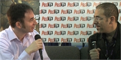 Two men sitting across from each other holding microphones during an interview against a Post TV backdrop.