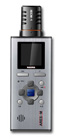 A silver handheld digital audio recorder with a black microphone on top and a small display screen.