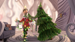 A man in a red shirt tangled in colorful Christmas lights next to a green Christmas tree.