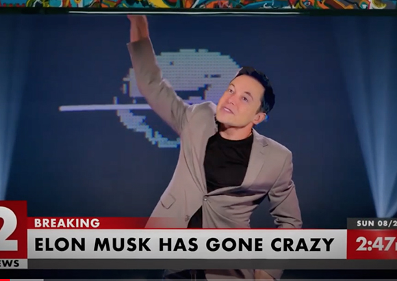 Elon Musk in a grey suit gesturing with one arm raised against a blue background with a pixelated logo.