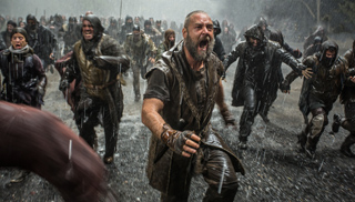 A bearded man in leather armor shouts while charging through rain alongside a large group of warriors.