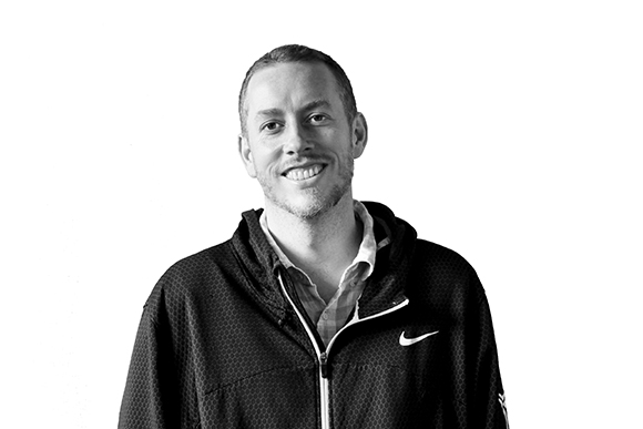 A smiling man wearing a black Nike zip-up hoodie against a plain white background.