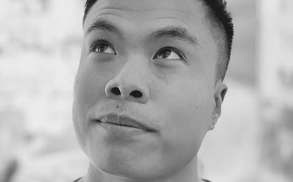 Black and white close-up of a man looking up toward the top left corner.