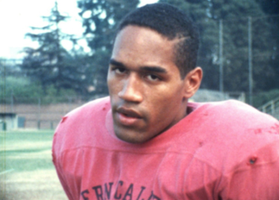 A man with short dark hair wearing a red jersey looking directly at the camera.