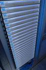 A vertical server rack containing numerous stacked silver and blue hardware modules.