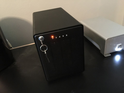 A black rectangular device with small lights and a silver key sits next to a white rectangular device.