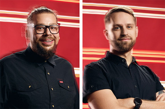 Two men with facial hair wearing black shirts against a red background with horizontal light streaks.