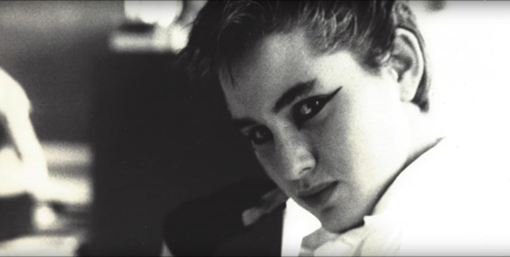 Black and white close-up of a person looking at the camera with heavy, dark winged eyeliner.