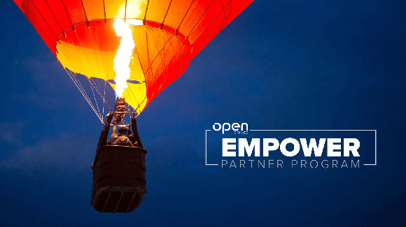 A bright orange hot air balloon with a visible flame rising against a dark blue sky.
