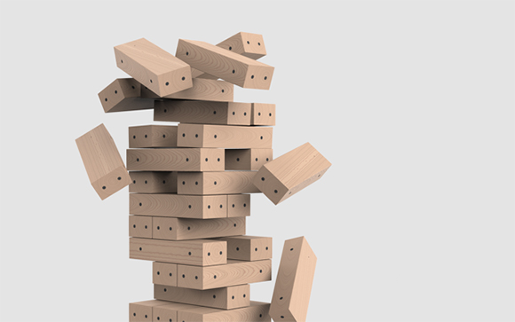 Light-colored wooden rectangular blocks tumbling and falling from a central stack against a plain background.