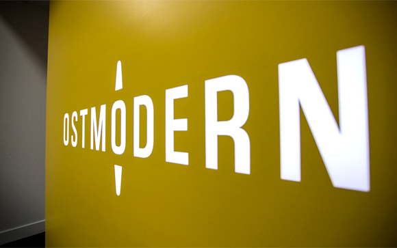 White text reading OSTMODERN on a bright yellow wall.